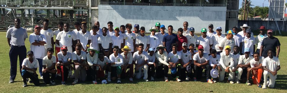  Leon Johnson (centre) is flanked by participants of the cricket clinic
