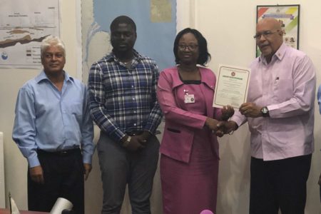 From right are GWI Managing Director Dr. Richard Van West-Charles receiving the certificate from the Guyana National Bureau of Standards (GNBS) Head of Conformity Assessment Department Rodlyn Semple while Water Quality Manager Deon Anderson (second from left) and Laboratory Consultant Dr. Karamchand Ramoutar look on. 
