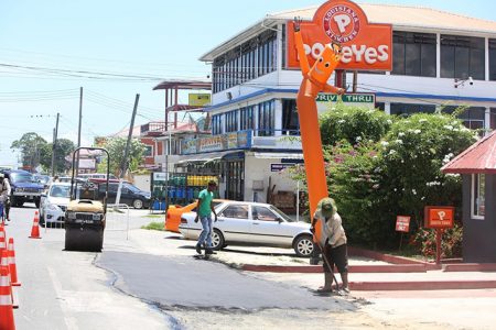 Getting it done: Works were carried out yesterday morning to patch a section of Vlissingen Road, in front of the Popeyes fast-food restaurant, which was damaged last month as a result of two breakages in an 18-inch transmission main. (Terrence Thompson photo) 