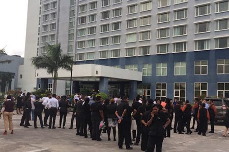 Staff of the Marriott Hotel stand outside after a tremor led them to exit the building.
