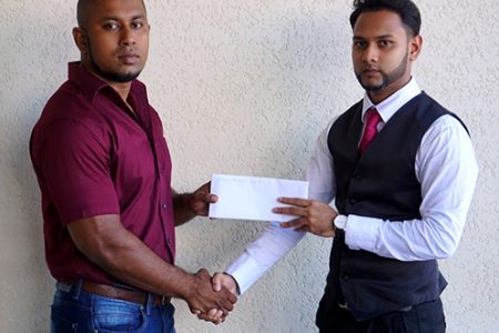 Stage of Champions organizer Sookram (left) receiving the sponsorship cheque from a representative of Tower Suites.
