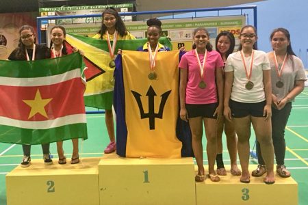 Priyanna Ramdhani posing with the Golden Arrowhead on the podium at CAREBACO Championships after winning the Under-17 Doubles.
