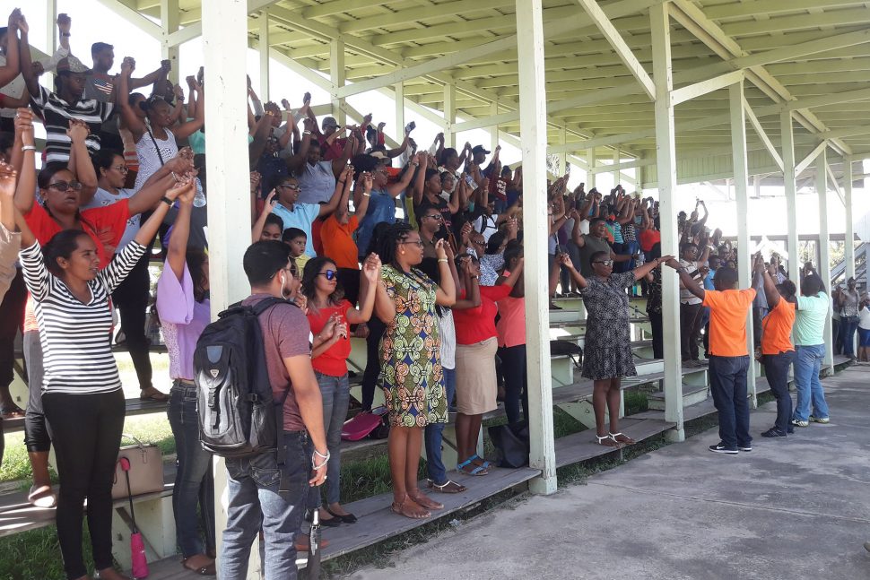Solidarity: Teachers hand in hand during yesterday’s meeting with union executives at the Albion Sports Complex in Berbice. 
