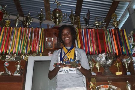 The Region’s best female junior long jumper, Chantoba Bright displaying some of the hardware she has earned during her young, successful career.