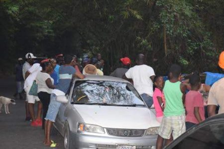 People gather along the Martha Brae River bank yesterday afternoon after news broke that a local raft captain and a five-year-old American boy who was on vacation on the island drowned during a rafting excursion. (Photo: JAMAICA OBSERVER/Horace Hines) 