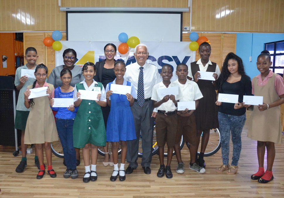 Deo Persaud (centre), Country Manager –  Massy Guyana poses with the students and other executives of the Group.