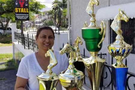 Devi Sunich, of the Trophy Stall displays some of the trophies up for grabs at Sunday’s horse race meet.