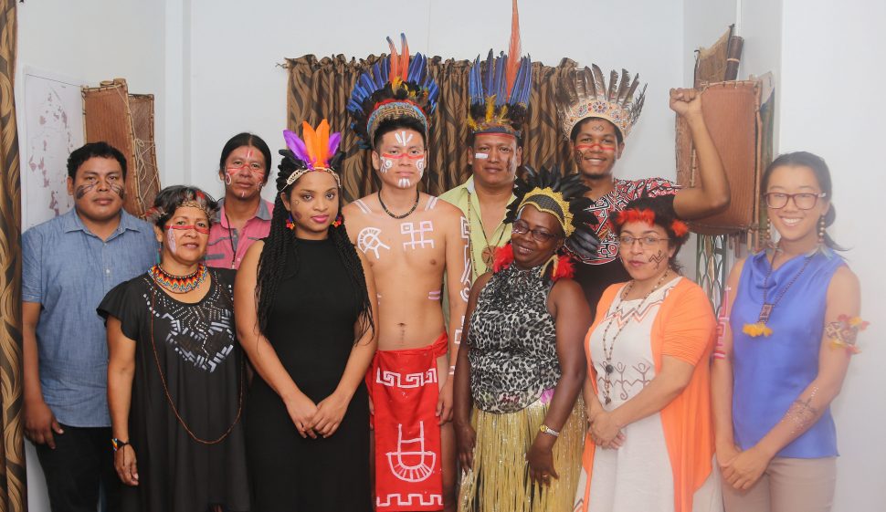 Staff of the Amerindian People’s Association wearing Indigenous People’s traditional and contemporary wear and accessories during their regular work hours at their Charlotte Street office on Tuesday to mark Indigenous Heritage Month being observed this month. Their apparel included cotton garments with hand-painted murals, feathered head wear, beaded necklaces made from seeds and ornamental glass beads, and face and body painting. At left in front row is APA Executive Director Jean La Rose. (Terrence Thompson photo) 