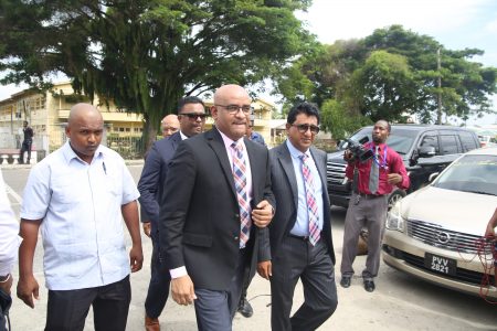 Former President Bharrat Jagdeo (second from left) arriving at the Special Organised Crime Unit (SOCU) headquarters on Camp Road yesterday. At right is attorney Anil Nandlall.
