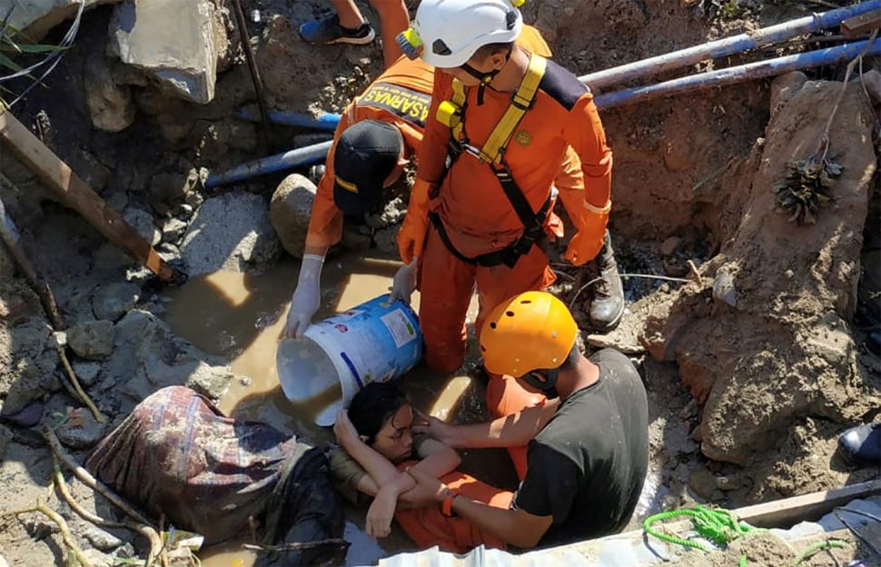 Search and rescue workers help rescue a person trapped in rubble following an earthquake and tsunami in Palu, Central Sulawesi, Indonesia. (Antara Foto/Darwin Fatir/via REUTERS)