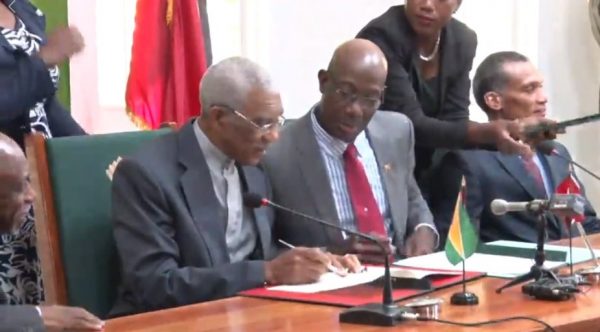 President David Granger (left) and Prime Minister Keith Rowley signing the MOU