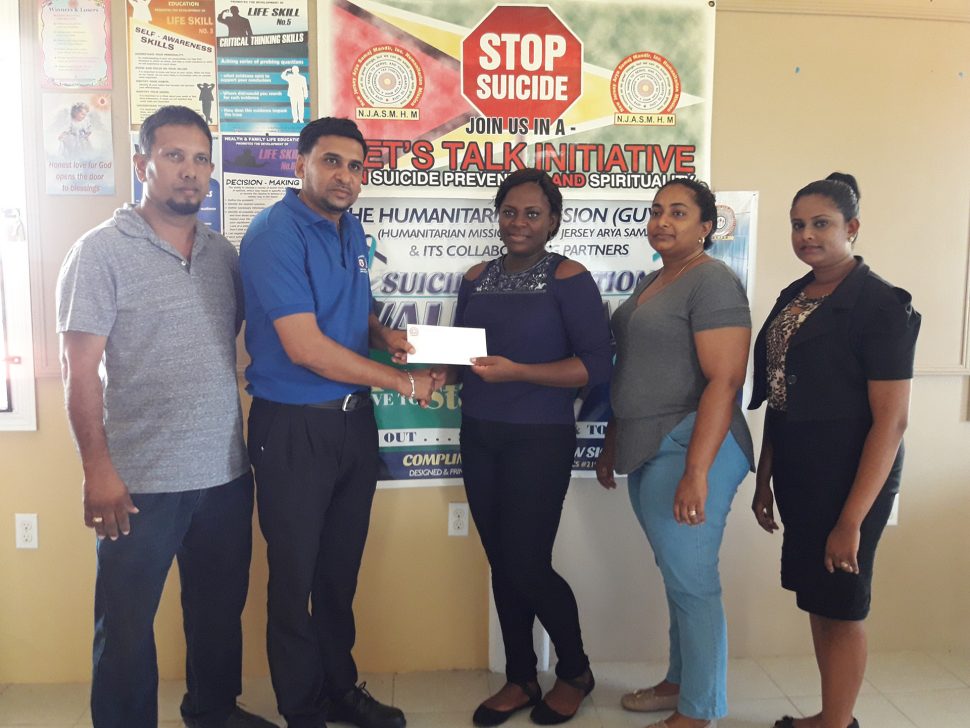 Trudy Sinclair (at centre) receives a cheque from Humanitarian Mission Guyana representatives on Thursday. 