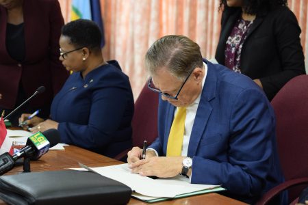 Minister of Public Health Volda Lawrence (left) and Dr. Gernot Grimm signing the MoU  (DPI photo)

