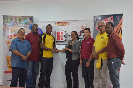Green Machine captain, Dwayne Schroeder (third from left) receives the sponsorship cheque from Beharry Brand Manager Monique Tiwari in the presence of Peter Green (left), Coach Sherlock Sam (second from left), GRFU PRO Esan Griffith (right), Manager Peter Campain (second from right) and Ryan Gonsalves