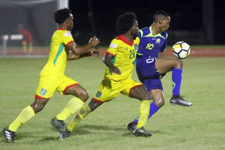 Vurlon Mills (left) and Trayon Bobb (no.20) challenging a Barbados player for possession of the ball during their clash in the CONCACAF Nations League at the National Track and Field Centre, Leonora.
