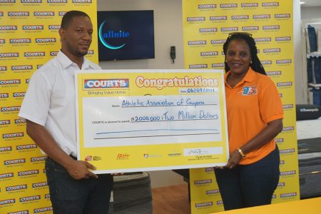 AAG’s Mayfield Taylor-Trim (right) is all smiles as receives the sponsorship cheque from Courts (Unicomer Guyana Inc.) Marketing Manager, Pernell Cummings.
