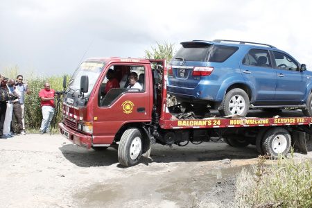 A wrecker removes the Toyota Fortuner belonging to the Embassy of El Salvador from the area off Warren Road, Cunupia, after the body of Jose Tito Rivas was found in its trunk yesterday.ABRAHAM DIAZ/GUARDIAN