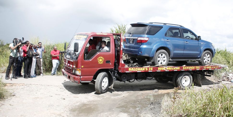 A wrecker removes the Toyota Fortuner belonging to the Embassy of El Salvador from the area off Warren Road, Cunupia, after the body of Jose Tito Rivas was found in its trunk yesterday.ABRAHAM DIAZ/GUARDIAN