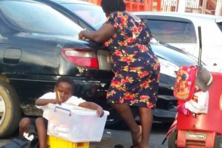 This lad was photographed  completing his school work as he waited on his mother to finish vending on Brickdam opposite the Public Buildings. (Photo Courtesy of Wenola Liverpool)