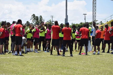 Golden Jaguars Head-Coach Michael Johnson [7th from left], making a point to his charges at the National Track and Field Centre, Leonora, ahead of their clash with Barbados in the CONCACAF Nations League Qualifiers
