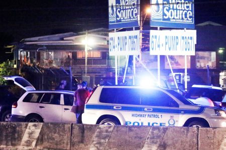 Policemen do initial interrogation of a suspect detained in connection with Natalie Pollonais’ kidnapping along the Churchill Roosevelt Highway in San Juan on Monday night.  (TRINIDAD GUARDIAN/Abraham Diaz)