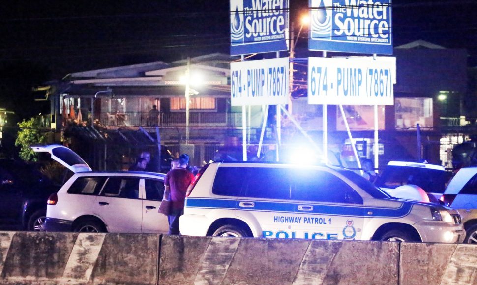 Policemen do initial interrogation of a suspect detained in connection with Natalie Pollonais’ kidnapping along the Churchill Roosevelt Highway in San Juan on Monday night.  (TRINIDAD GUARDIAN/Abraham Diaz)