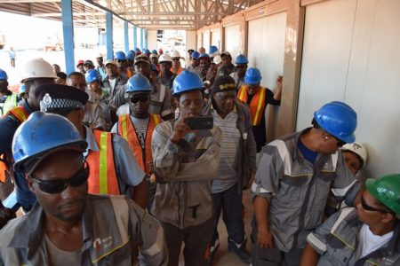 Workers paying keen attention to an address in April during a visit by Minister of Natural Resources, Raphael Trotman.