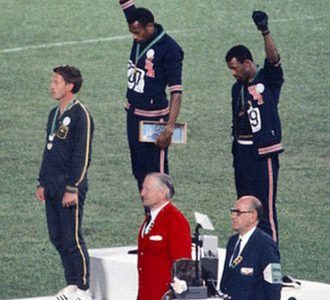 Gold medalist Tommie Smith(center) and bronze medalist John Carlos (right) showing the raised fist on the podium after the 200 m race at the 1968 Summer Olympics.

