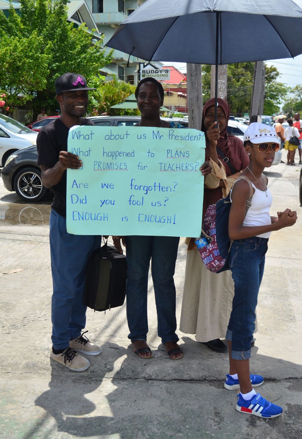 Striking teachers with a message for President David Granger on Brickdam yesterday. (Orlando Charles photo)
