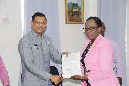 Minister of Education Nicolette Henry and Managing Director of B.K International Inc Brian Tiwarie displaying the signed contract for the construction of the Good Hope Secondary School. (Ministry of Education photo)