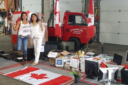 Rita Persaud (right) and one of the donors, Mila Gould, while packing one of the shipments last month. 