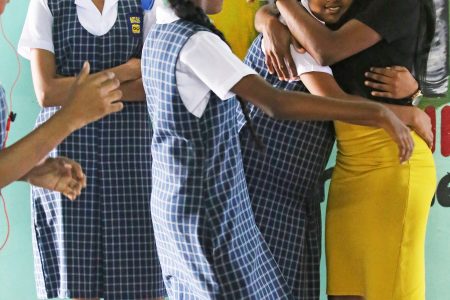 Showing appreciation: A teacher from the North Georgetown Secondary School received the warm embrace of some of her students yesterday as World Teachers’ Day was celebrated across the country.
