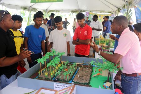 A National Agricultural Research and Extension Institute (NAREI) representative explaining a display on Sustainable Pest and Disease Management to students of the New Amsterdam Multilateral School who were among the visitors to the institute at Mon Repos yesterday during an Open Day. (Photo by Terrence Thompson) 