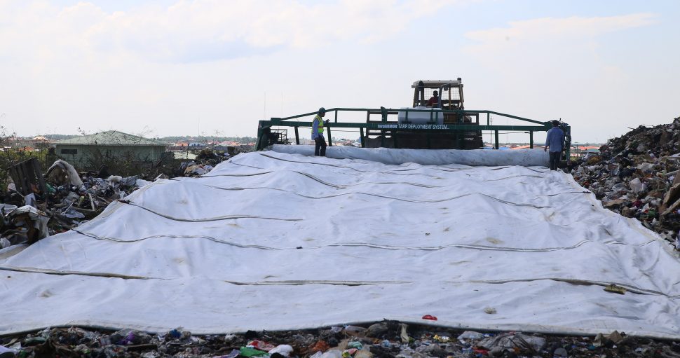 A deployer laying tarpaulin on compacted garbage at the Haags Bosch Landfill, where it has aided in saving space. See story on centre pages. (Photo by Terrence Thompson)
