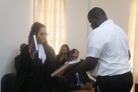 Kaycia Ellis, who recently obtained her Legal Education Certificate from the Hugh Wooding Law School, was yesterday admitted to the local bar.
Senior Counsel Edward Luckhoo presented a petition for her admission to Justice Nareshwar Harnanan at the High Court in Georgetown.
Ellis, a former student of the Bishops’ High School, completed her LLB at the University of Guyana in 2016 before attending the Hugh Wooding Law School.
In his petition to the court, Senior Counsel Luckhoo stated that Ellis trained at his firm from June to August and he commended her work, especially in the area of research. The attorney noted that although Ellis desires to open her own practice in the future, in the interim she would serve as a Judicial Research Assistant. In photo, Ellis reads the attorney’s oath. (Terrence Thompson photo)