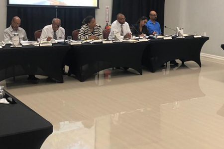 PUCGTT: Commissioners and other members of the Public Utilities Commission (PUC) at centre along with the representatives of GTT on the left and representatives of the Guyana Consumers Association at right.