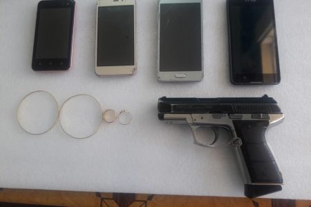 The recovered phones and jewellery that were stolen during an attack on a Zeelugt, East Bank Essequibo couple on Friday evening. Also in photo is the handgun allegedly brandished by Noel “Kevin” Kissoon during a fatal confrontation with police outside of his home yesterday morning. 