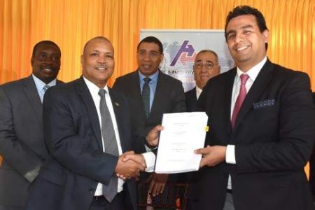 Audley Deidrick (left), president & CEO of the Airports Authority of Jamaica, presents a copy of the signed Norman Manley International Airport (NMIA) Concession Agreement to Raul Revuelta Musalem (right), CEO of Grupo Aeroportuario del Pacifico (GAP), witnessed by (from left at back), Robert Montaque, minister of transport & mining; Prime Minister Andrew Holness; and William Shagoury, custos rotulorum of Clarendon. (Photo: Garfield Robinson) 
