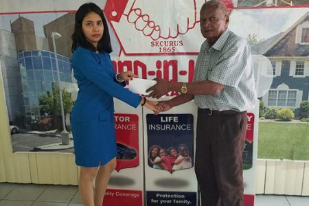 Business Development personnel at Hand-in-Hand Mutual Fire and Life Insurance, Soma Bharrat, hands over the sponsorship to event organiser, Hassan Mohammed
