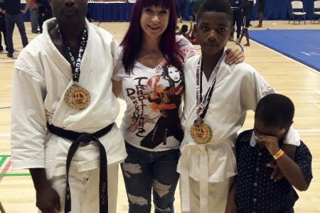 Sensi Troy Bobb (left) and Niquann Fevrier (third from left) with the famous movie star and grand master in Martial Arts, Cynthia Rothrock after their victory.
