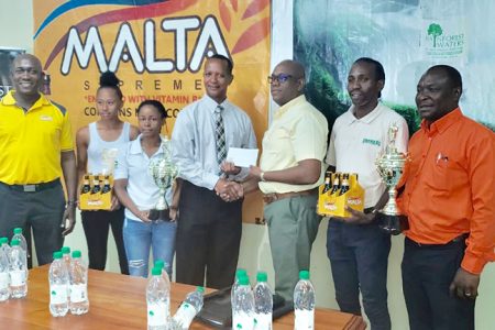 Clive Pellew, Brand Manager of Rainforest Water handed over a sponsorship cheque to President of the Athletics Association of Guyana (AAG), Aubrey Hutson, yesterday at Thirst Park following the launch of the 16th edition of the South American 10K event.
