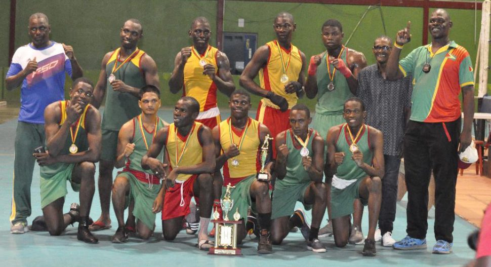 Quincy Boyce (at centre with the best boxer award) and the GDF outfit pose for a photo after the curtain came down on this year’s Lennox Blackmore Intermediate Championships Sunday night at the National Gymnasium.
