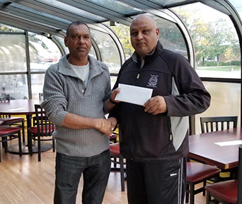 At left, proprietor of Windies, Fazil Mirza, hands over the cheque for an undisclosed sum to GFSCA vice-president Ramesh Sunich, at the Scarborough, Toronto entity.
