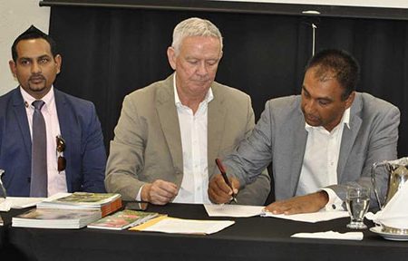 Guyana Tourism Authority head, Mitra Ramkumar (extreme left) looks on as Roddy Carr (center) and Aleem Hussain (right) sign the $20b deal.
