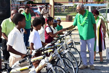 President David Granger greets a recipient of a bicycle gifted through the Public Education Transport Service on Monday at Anna Regina. (Department of Public Information photo)