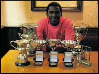 Ryan Hercules poses with some of his accolades during his stint in England
