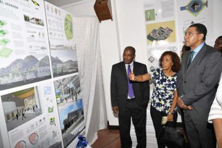 Prime minister Andrew Holness (right) listens to Gwyneth Anderson (centre), one of five architects that was shortlisted, explain her drawing of the new Parliament building at the opening of the Houses of Parliament Design Exhibition. Looking on is Edmond Mding, one of Anderson’s team members, at the Jamaica Conference Centre, yesterday.