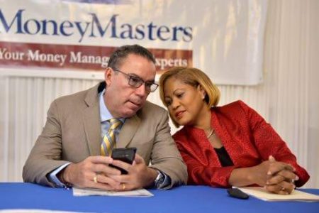 Minister without portfolio in the Ministry of Economic Growth and Job Creation Daryl Vaz (left), in discussion with MoneyMasters Limited President Claudette Crooks