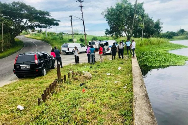 FALSE ALARM: Police and undertakers at the Ste Madeleine pond.