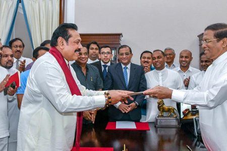 Sri Lanka’s former President Mahinda Rajapaksa (Front-L) is sworn in as the new Prime Minister before President Maithripala Sirisena in Colombo, Sri Lanka October 26, 2018. Sri Lanka’s President’s Office/Handout via REUTERS